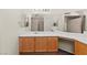 Bathroom featuring a single sink, wood cabinets, a makeup vanity, and a tiled walk-in shower at 7825 White Grass Ave, Las Vegas, NV 89131