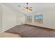 A bright bedroom with two windows, neutral walls, and plush brown carpet flooring at 7825 White Grass Ave, Las Vegas, NV 89131