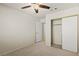 Bright bedroom features neutral carpet, ceiling fan, closet, and an open doorway at 7825 White Grass Ave, Las Vegas, NV 89131