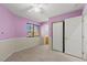 Charming bedroom with pink accent wall, closet, and adjacent bathroom at 7825 White Grass Ave, Las Vegas, NV 89131