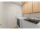 Functional laundry room with washer, dryer, and ample cabinet space at 7825 White Grass Ave, Las Vegas, NV 89131