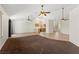 Spacious living area featuring tile flooring, carpet inserts, and a view of the kitchen at 7825 White Grass Ave, Las Vegas, NV 89131
