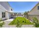 Large backyard featuring a swing set, artificial grass and rock landscaping at 7849 Meandering Light Ave, Las Vegas, NV 89131
