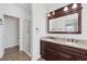 Bathroom with dual sinks, granite countertop, dark wood cabinets, a glass-enclosed shower, and modern fixtures at 7849 Meandering Light Ave, Las Vegas, NV 89131