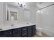 Bathroom featuring double sinks, modern mirrors, and a shower-tub combination at 7849 Meandering Light Ave, Las Vegas, NV 89131