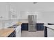 Kitchen with stainless steel appliances, white upper cabinets, and blue lower cabinets at 7849 Meandering Light Ave, Las Vegas, NV 89131