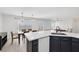 Open kitchen with a breakfast bar, dark blue cabinets, tile floors, and a view into the dining area at 7849 Meandering Light Ave, Las Vegas, NV 89131