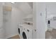Efficient laundry room featuring a side-by-side washer and dryer with built-in shelving for storage at 7849 Meandering Light Ave, Las Vegas, NV 89131