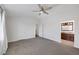 Spacious main bedroom with neutral carpet, ceiling fan, and an en-suite bathroom visible through a doorway at 7849 Meandering Light Ave, Las Vegas, NV 89131