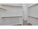 Spacious walk-in closet offering ample storage space with shelves and wooden rods at 7849 Meandering Light Ave, Las Vegas, NV 89131