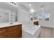 Bright bathroom features a soaking tub with tile surround, wood cabinets, and a glass enclosed shower at 8562 Burning Bridge Ct, Las Vegas, NV 89131