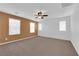 Large bedroom features neutral carpet, a ceiling fan, and multiple windows with coverings at 8562 Burning Bridge Ct, Las Vegas, NV 89131