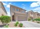 Exterior shot of a two-story home with a two-car garage and desert landscaping at 8562 Burning Bridge Ct, Las Vegas, NV 89131