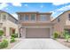 Two-story home featuring a two-car garage, neutral paint, and desert landscaping at 8562 Burning Bridge Ct, Las Vegas, NV 89131