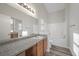 Bright bathroom features a large mirror, granite counters and a shower-over-tub at 905 Harp Way, North Las Vegas, NV 89032