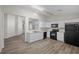 Bright kitchen features white cabinets, black appliances, and modern countertops with wood-look vinyl flooring at 905 Harp Way, North Las Vegas, NV 89032