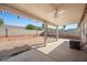 Covered patio area with ceiling fan overlooking a spacious backyard framed by block wall at 905 Harp Way, North Las Vegas, NV 89032