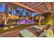 Resort-style backyard oasis with lush landscaping, pergola, and luxurious lounge chairs at 9135 Hickam Ave, Las Vegas, NV 89129