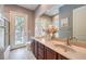 Bright bathroom featuring a dual-sink vanity, outdoor access, and framed desert-themed art at 9135 Hickam Ave, Las Vegas, NV 89129