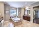 Elegant bathroom with a soaking tub, granite counters, and dark wood cabinets at 9135 Hickam Ave, Las Vegas, NV 89129