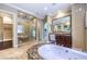 Luxurious bathroom featuring a large tub, walk-in shower, and dark wood vanity at 9135 Hickam Ave, Las Vegas, NV 89129