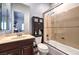 Well-lit bathroom featuring a shower-over-tub, dark wood vanity, and a toilet with a storage cabinet above at 9135 Hickam Ave, Las Vegas, NV 89129