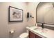 Tastefully decorated powder room with a decorative mirror, modern faucet, and stylish marble countertop at 9135 Hickam Ave, Las Vegas, NV 89129