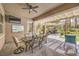 Relaxing covered patio with ceiling fan, outdoor dining, tv, and additional seating area at 9135 Hickam Ave, Las Vegas, NV 89129