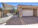 Attached two-car garage features stone accents, an automatic door, and additional parking with a covered spot at 9135 Hickam Ave, Las Vegas, NV 89129