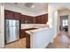 Modern kitchen featuring stainless steel appliances, dark wooden cabinetry, and an adjacent eating bar at 9135 Hickam Ave, Las Vegas, NV 89129