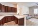 Modern kitchen with bar and view into adjacent seating area and kitchen cabinets and stainless steel fridge at 9135 Hickam Ave, Las Vegas, NV 89129