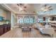 Spacious living room with a TV, large windows, hardwood flooring, and comfortable seating at 9135 Hickam Ave, Las Vegas, NV 89129