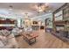 Large living room with a stone fireplace, open floor plan, hardwood floors, and comfortable furnishings at 9135 Hickam Ave, Las Vegas, NV 89129