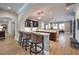 Open-concept bar area with bar stools and dark wood cabinets that flows into the living room at 9135 Hickam Ave, Las Vegas, NV 89129