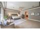 Large main bedroom with seating area, carpet, and an arched entry to the bathroom at 9135 Hickam Ave, Las Vegas, NV 89129