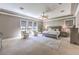 Spacious main bedroom with sitting area, carpeted floors, ceiling fan, and large windows at 9135 Hickam Ave, Las Vegas, NV 89129