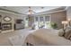 Main bedroom featuring a fireplace, sitting area, TV, ceiling fan, and large windows at 9135 Hickam Ave, Las Vegas, NV 89129