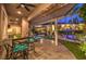 Expansive covered patio with outdoor kitchen, bar seating, and picturesque backyard view at 9135 Hickam Ave, Las Vegas, NV 89129