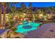Stunning backyard oasis with a large pool, lush landscaping, fire pit, and mesmerizing mountain views at 9135 Hickam Ave, Las Vegas, NV 89129