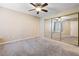 Spacious carpeted bedroom with large mirrored closet and ceiling fan at 9325 W Desert Inn Rd # 104, Las Vegas, NV 89117