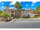 Attractive condo building featuring stucco facade and mature landscaping, under a bright blue sky at 9325 W Desert Inn Rd # 104, Las Vegas, NV 89117
