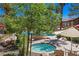A beautiful pool and spa area surrounded by lush greenery, lounge chairs, and shaded tables at 9325 W Desert Inn Rd # 104, Las Vegas, NV 89117