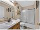 Stylish bathroom features modern vanity with marble countertop, bathtub with sliding door, and decorative wall accents at 100 Crossfoot Terrace Ct, Henderson, NV 89002