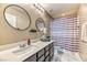 Bathroom with double mirrors, white countertops, and a shower with a curtain at 10042 Bismuth St, Las Vegas, NV 89183