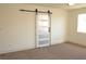 Bedroom features a modern barn door, neutral paint, and carpet flooring at 1025 Appaloosa Hills Ave, North Las Vegas, NV 89081