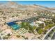 Stunning aerial view of community amenities with tennis and bocce ball courts, a pool, clubhouse, and scenic mountain backdrop at 10413 Marymont Pl, Las Vegas, NV 89134