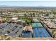 Community amenities aerial view: tennis courts, a swimming pool, clubhouse, parking lot, mature landscaping, and mountain views at 10413 Marymont Pl, Las Vegas, NV 89134