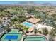 Aerial view features golf course, swimming pool, recreation center, and tennis courts with mountain views at 10413 Marymont Pl, Las Vegas, NV 89134