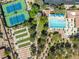 Aerial view showcases tennis, bocce ball, swimming pool and clubhouse surrounded by lush green landscaping and mature trees at 10413 Marymont Pl, Las Vegas, NV 89134