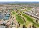 Aerial view of community with a golf course, tennis courts, a community pool and clubhouse among residential houses and desert landscaping at 10413 Marymont Pl, Las Vegas, NV 89134